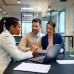 Young couple reviewing documents with a financial advisor, discussing reporting requirements for Form 8938.