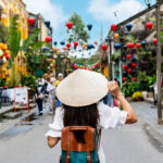 Woman in a traditional hat exploring Hoi An, reflecting the cultural richness experienced by Americans living in Vietnam.