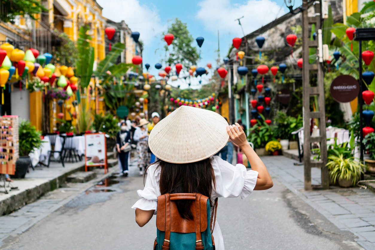 Woman in a traditional hat exploring Hoi An, reflecting the cultural richness experienced by Americans living in Vietnam.