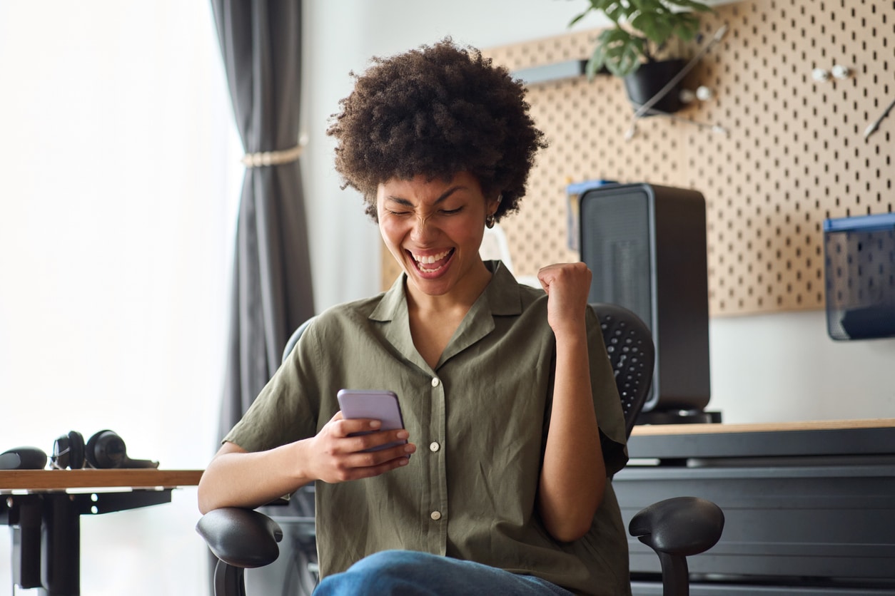 Woman reacting excitedly to something on her phone, capturing the kind of unexpected gift or foreign transfer that may require Form 3520.