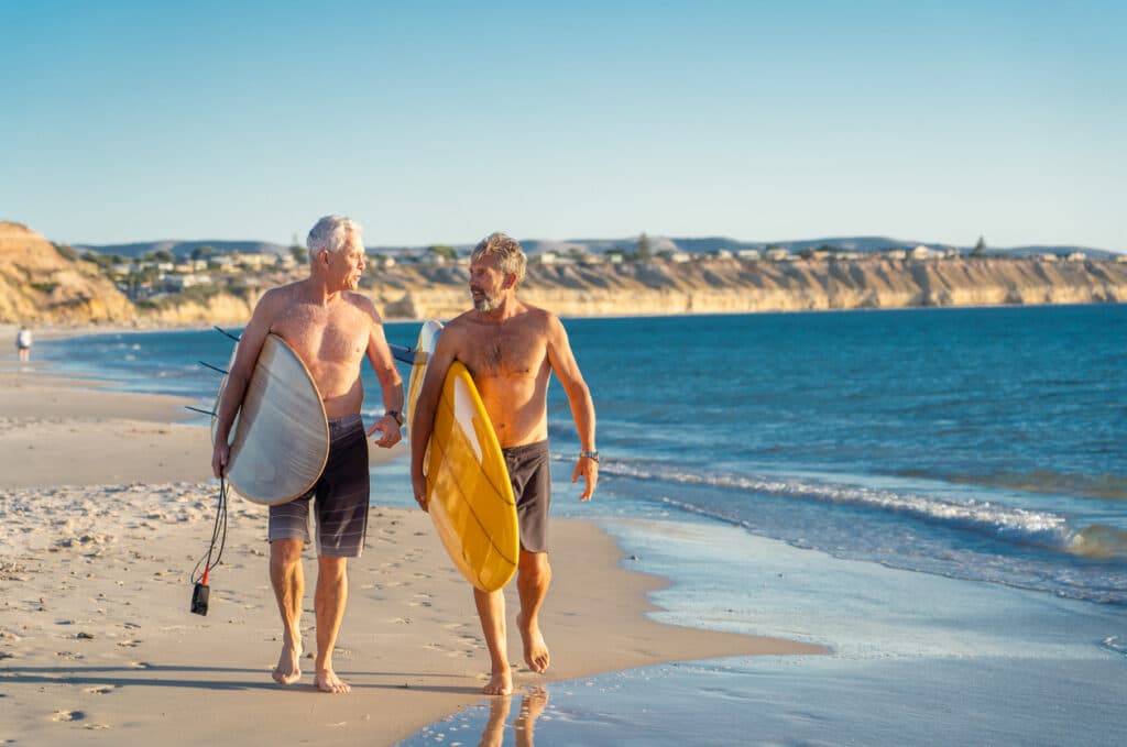 Active retirees heading to surf, reflecting the lifestyle supported by superannuation in Australia.