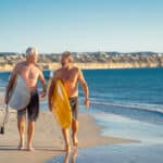 Active retirees heading to surf, reflecting the lifestyle supported by superannuation in Australia.