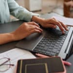 Businesswoman working on her laptop, researching delinquent FBAR filing procedures for foreign account compliance.