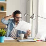 Confused freelancer reviewing charts and numbers, facing the complexities of the foreign tax credit limitation.