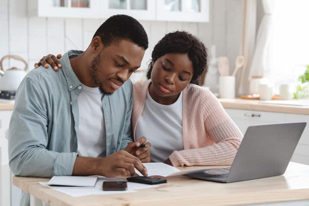 Young couple reviewing financial documents at the kitchen table, reflecting the kind of tax paperwork that may involve Form 1040-NR.