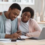 Young couple reviewing financial documents at the kitchen table, reflecting the kind of tax paperwork that may involve Form 1040-NR.