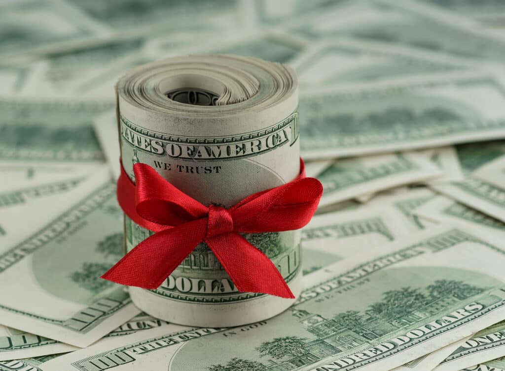 Cash tied with a red ribbon, representing a financial gift that may require filing Form 709 for gift tax reporting.