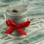 Cash tied with a red ribbon, representing a financial gift that may require filing Form 709 for gift tax reporting.