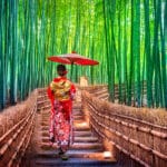 Woman in a traditional kimono walking through Kyoto’s bamboo forest, reflecting the cultural experience of Americans living in Japan.