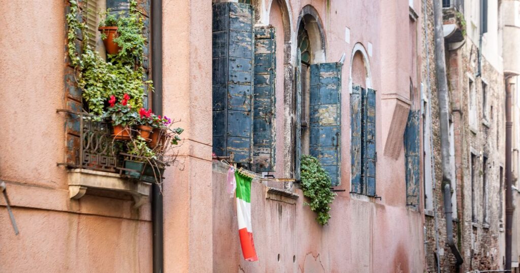 Italian flag draped outside a traditional Italian home