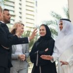 Taxes in Dubai - tax in UAE - group of expat businesspeople in the UAE speaking in a group outside