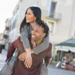 Smiling couple exploring a city while traveling abroad, navigating life and taxes for US citizens living abroad.