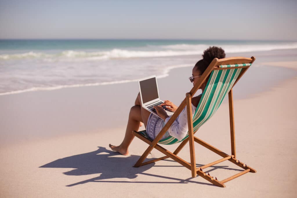 Remote worker enjoying beach life, exploring expat rules like the bona fide residence test.