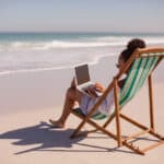 Remote worker enjoying beach life, exploring expat rules like the bona fide residence test.