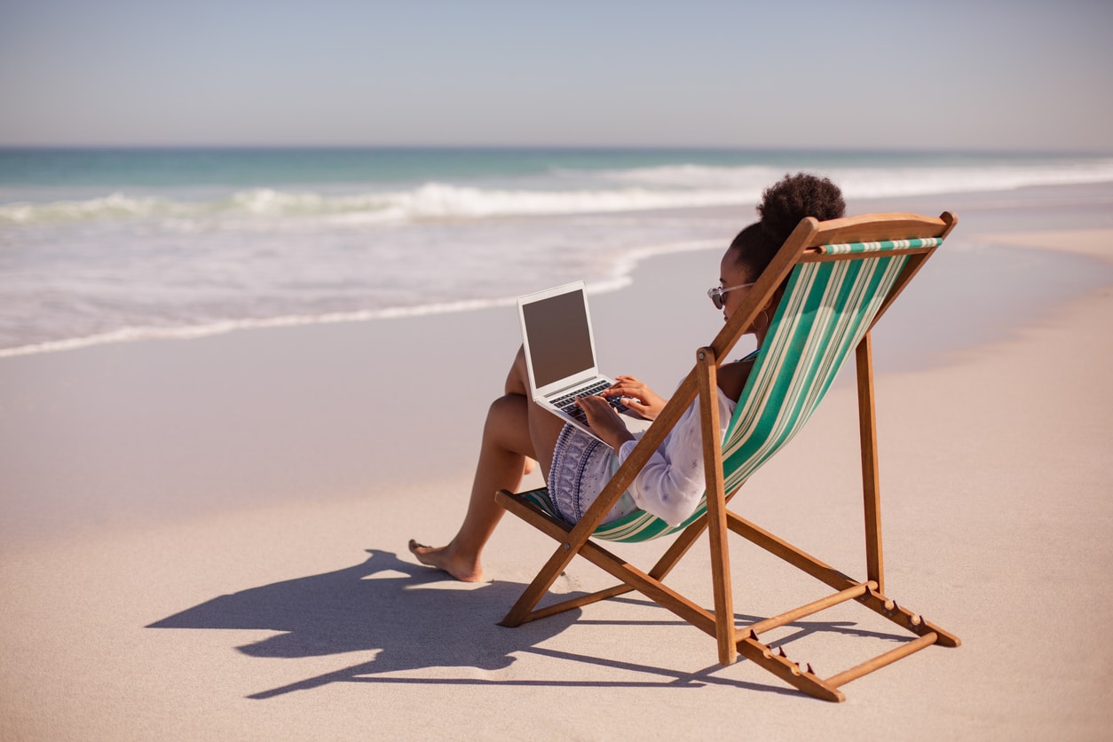 Remote worker enjoying beach life, exploring expat rules like the bona fide residence test.