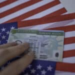 US permanent resident card on an American flag, representing the tax and filing obligations of green card holders.