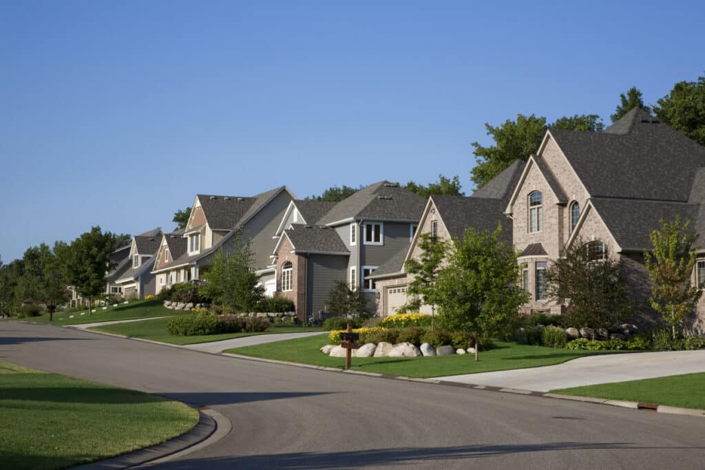 Upscale homes on a suburban street, reflecting the kind of rental property income often reported on Schedule E.