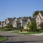 Upscale homes on a suburban street, reflecting the kind of rental property income often reported on Schedule E.