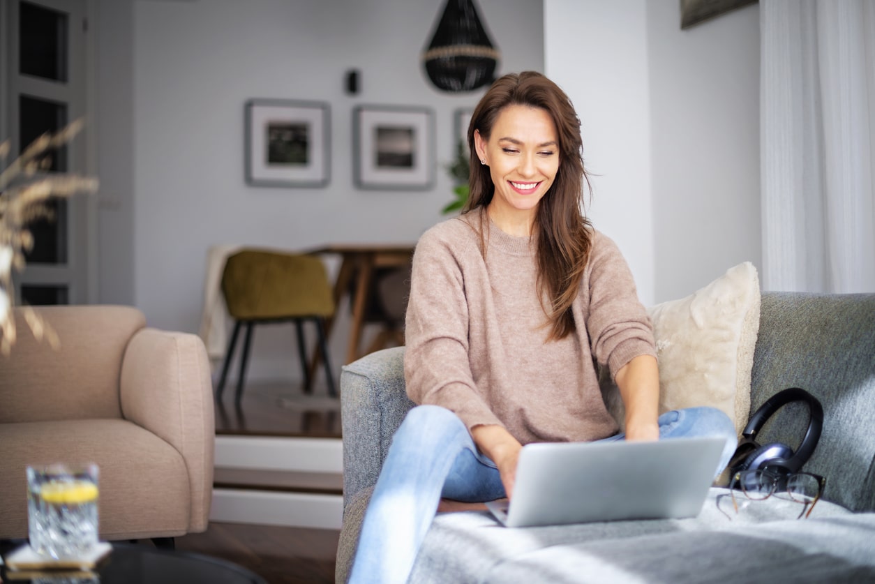 Woman using a laptop on the sofa, preparing to file Form 1040.