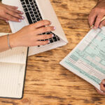 Two accountants completing tax forms side by side, illustrating the collaborative process of Streamlined Filing Procedures.