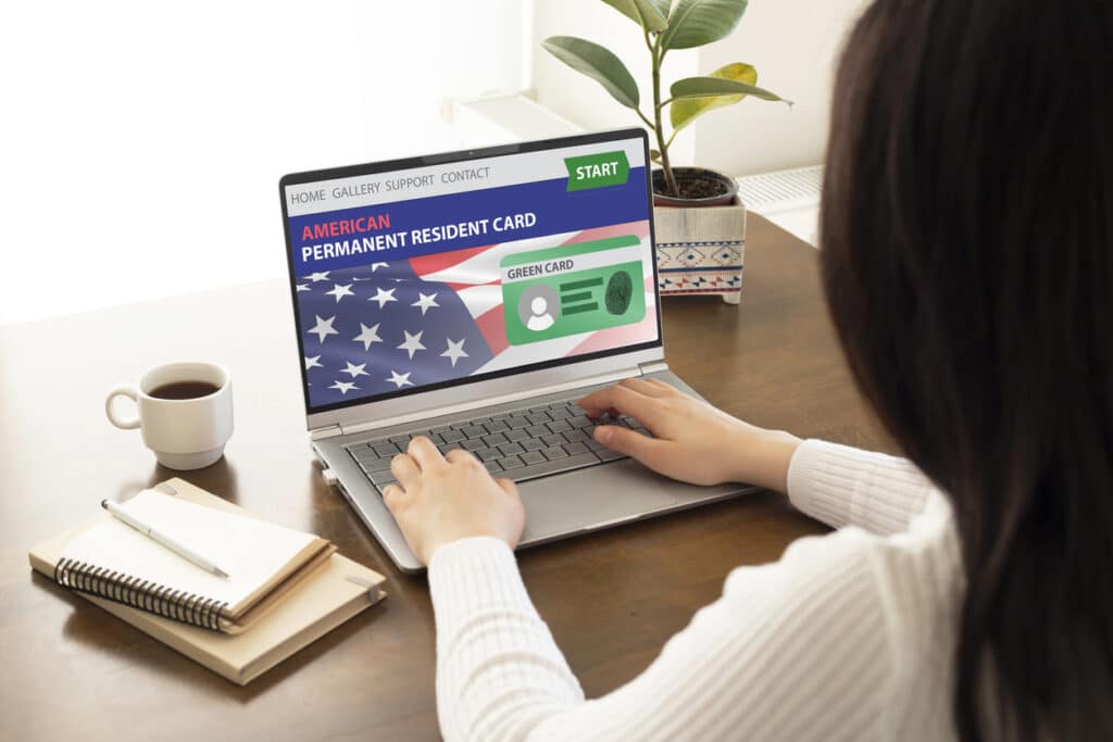 Woman completing an online application for American permanent residency, related to green cards.