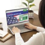 Woman completing an online application for American permanent residency, related to green cards.