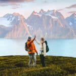 Hiking couple high-fives on a mountain summit, representing the reward of navigating complex filings like Form 1116 for the foreign tax credit.