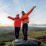 Couple celebrating together on a scenic hilltop, capturing the security and shared future supported by spousal Social Security benefits.