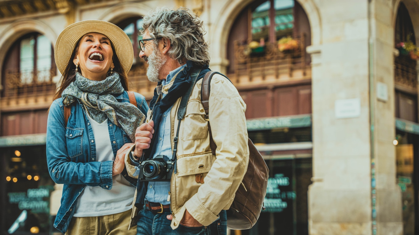 Happy older couple walking through a city street, reflecting the everyday life of people who may need an ITIN for US tax purposes.
