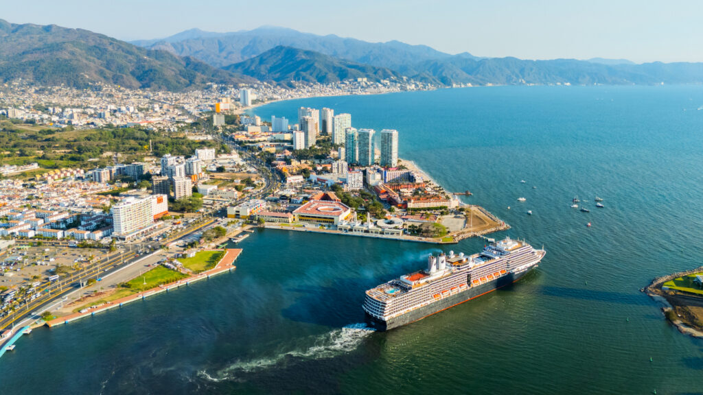 Cruise ship leaving Puerto Vallarta at sunset, capturing the coastal lifestyle that attracts people moving to Mexico.