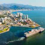 Cruise ship leaving Puerto Vallarta at sunset, capturing the coastal lifestyle that attracts people moving to Mexico.
