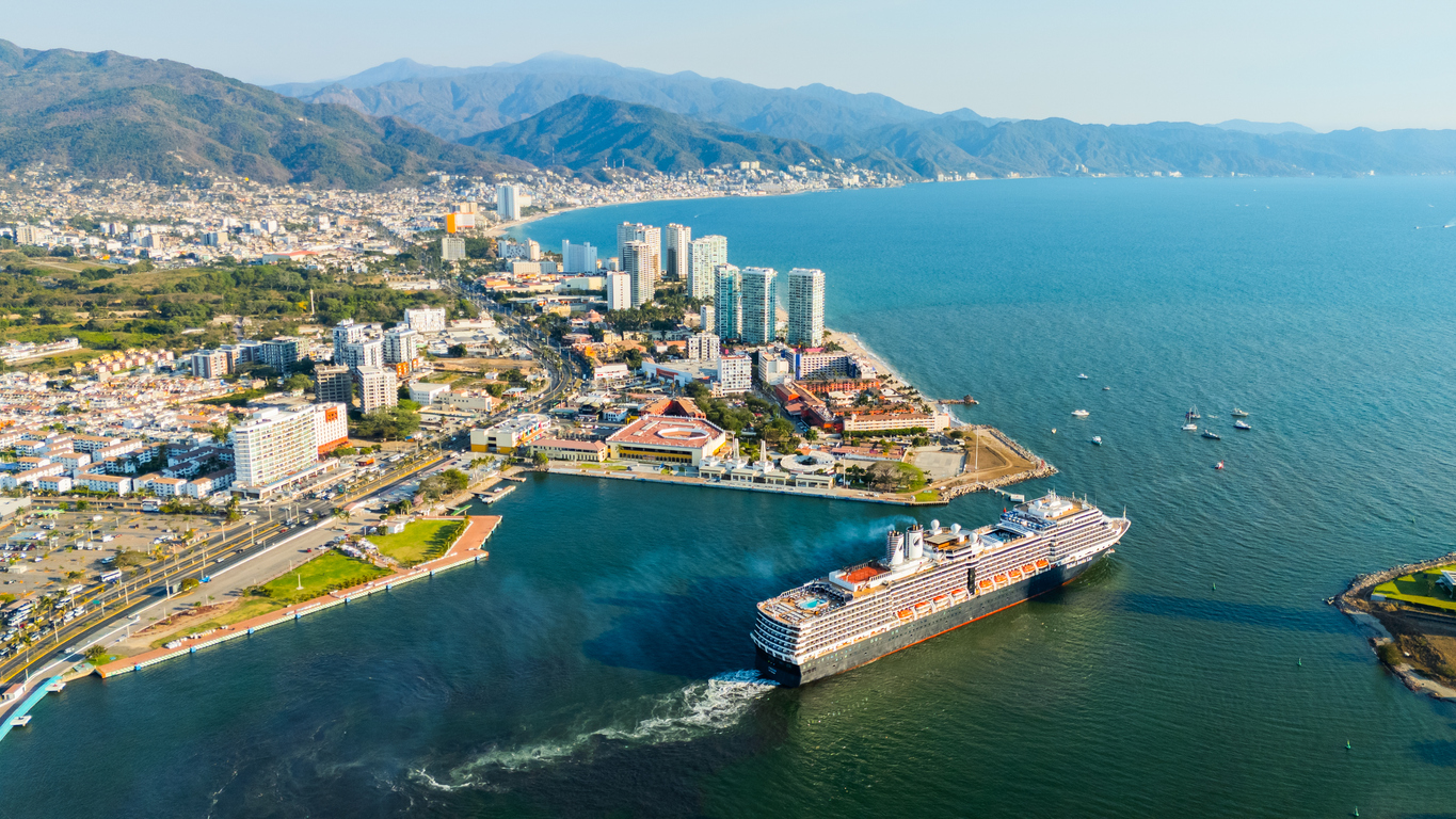 Cruise ship leaving Puerto Vallarta at sunset, capturing the coastal lifestyle that attracts people moving to Mexico.