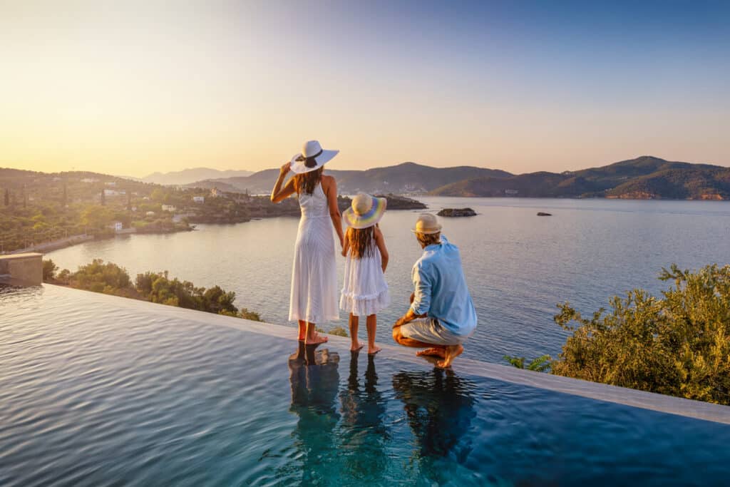 Family by a pool at sunset during an overseas stay, reflecting the lifestyle abroad that still comes with US expat taxes.