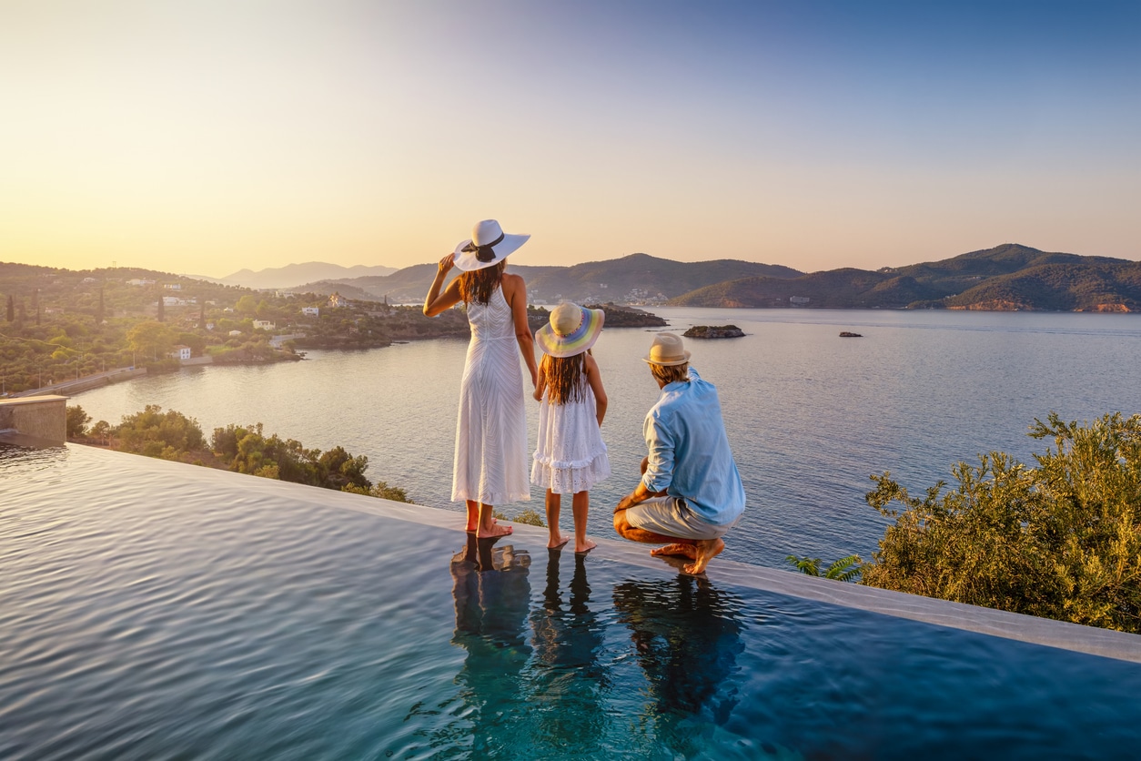 Family by a pool at sunset during an overseas stay, reflecting the lifestyle abroad that still comes with US expat taxes.