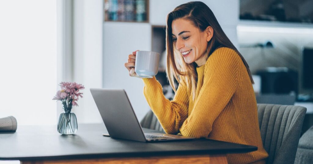 Woman drinking coffee looking at her laptop during a consultiation with Bright!Tax