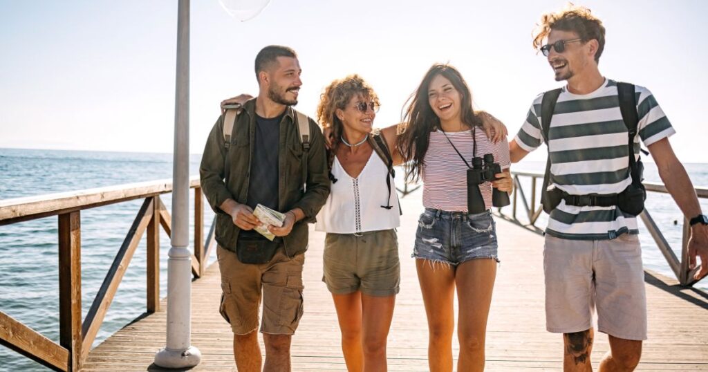 A group of four digital nomads walking along a pier in the sun