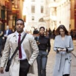 Young professionals walking along a London street, capturing the pace of life for a US citizen working in the UK.