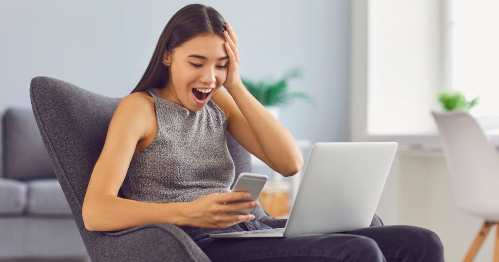 A US expat looking at her laptop in surprise because she has just won the lottery and needs to pay taxes on lottery winnings.