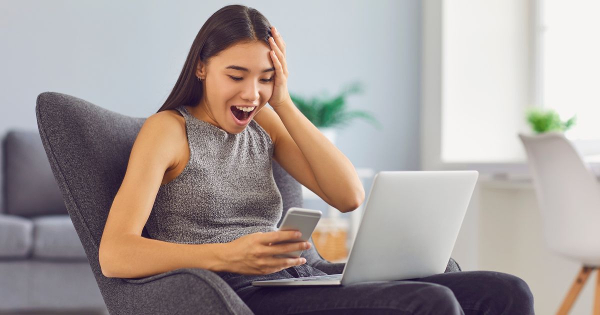 A US expat looking at her laptop in surprise because she has just won the lottery and needs to pay taxes on lottery winnings.