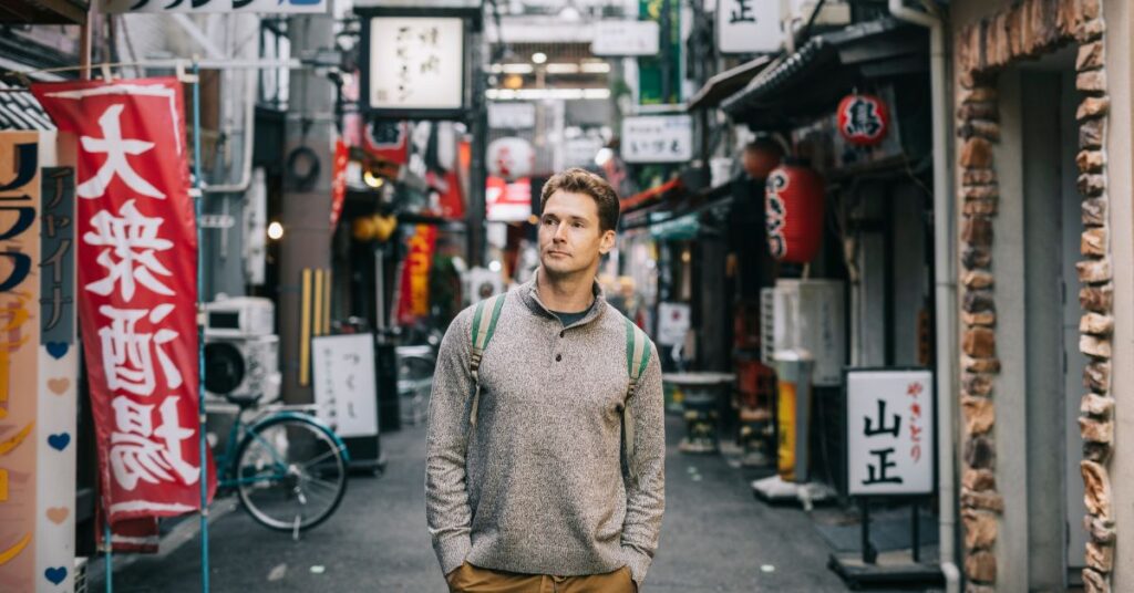 US expat living in Japan walks down a busy city street