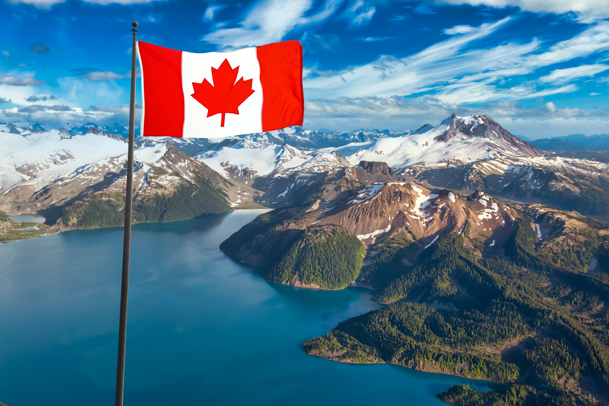 Aerial view of Garibaldi Lake with Canadian flag overlay—an iconic landscape for anyone earning taxable income in Canada.