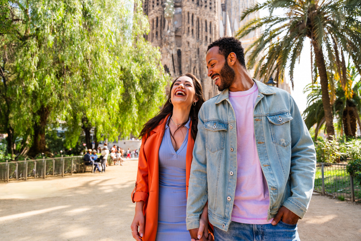 Smiling couple visiting Barcelona, where expats may benefit from tax perks under the Beckham Law in Spain.