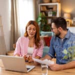 Couple discussing their tax return, weighing the impact of tax deductions vs tax credits on their refund.