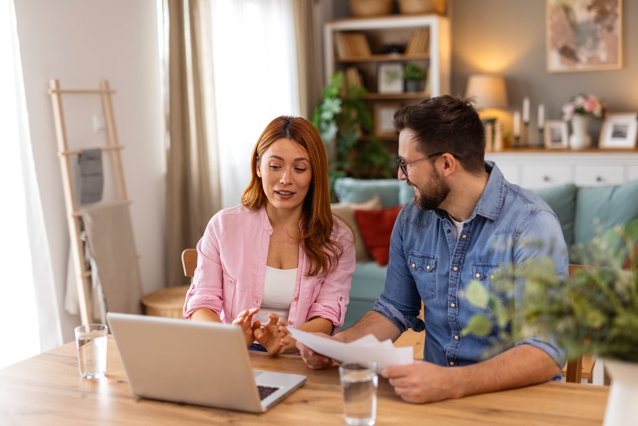 Couple discussing their tax return, weighing the impact of tax deductions vs tax credits on their refund.