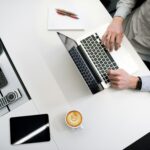 man sitting in a table while using his laptop