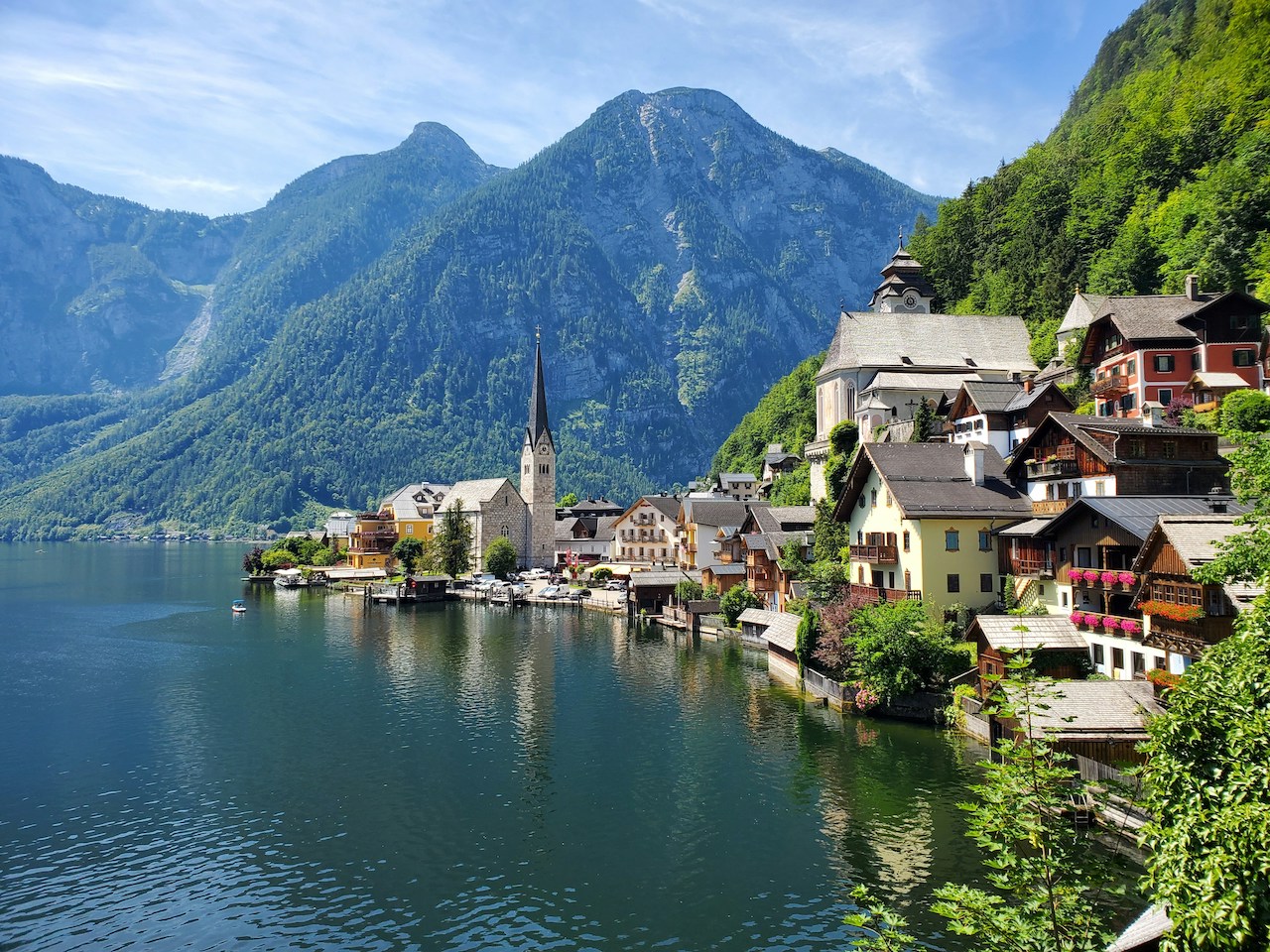 Charming lakeside village surrounded by mountains, representing the storybook lifestyle of Americans living in Austria.