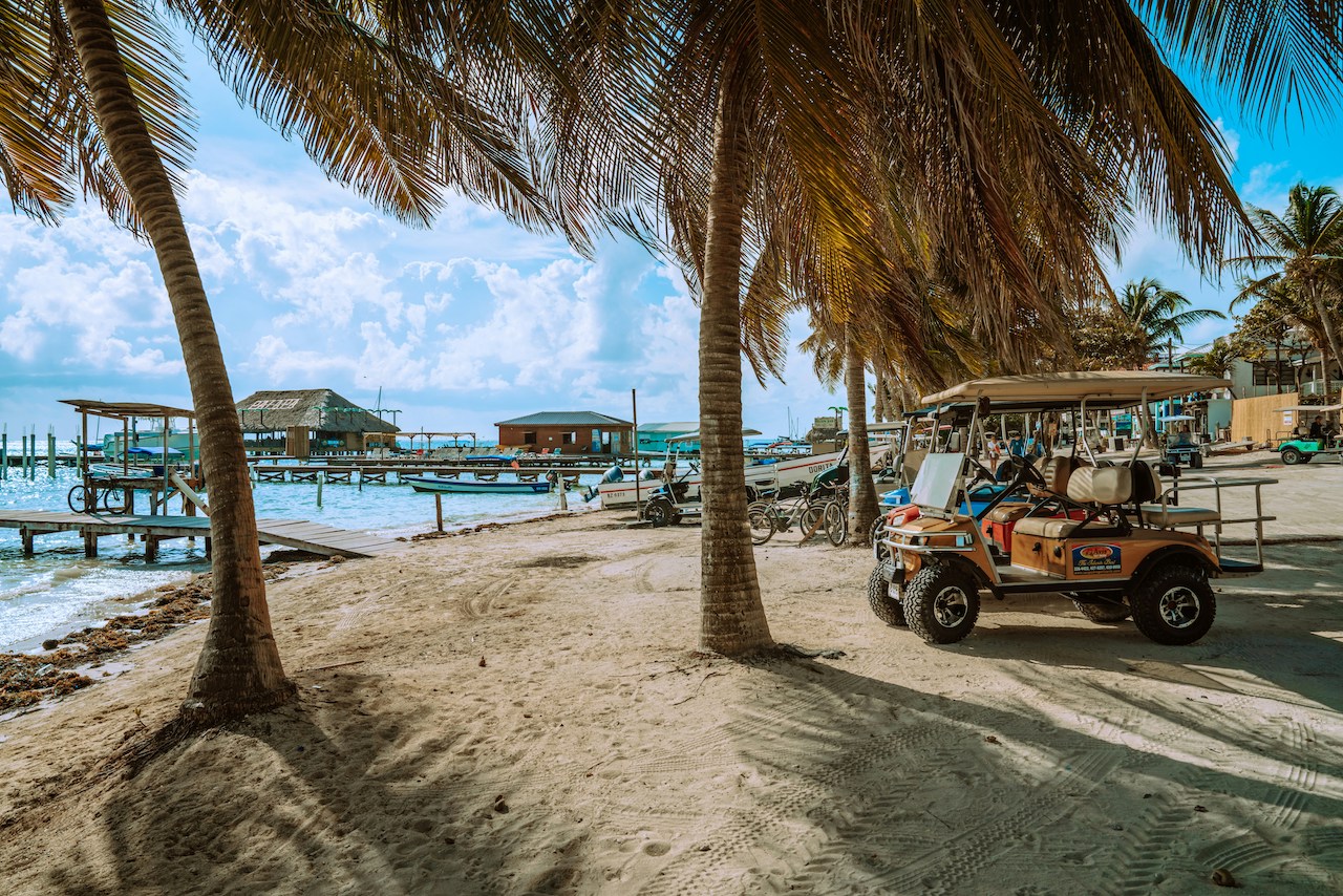 Rickshaws and golf carts near the beach—relaxed transportation for Americans living in Belize’s tropical settings.