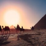 Camel riders pass the pyramids—historic views that are part of daily life for Americans living in Egypt.