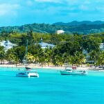 Boats drift on clear water near Negril, capturing the laid-back lifestyle of Americans living in Jamaica.