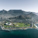 City nestled near a mountain range, representing the diverse landscapes experienced by Americans living in South Africa.